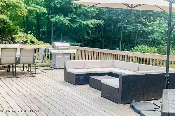 a view of a patio with couches table and chairs and wooden floor