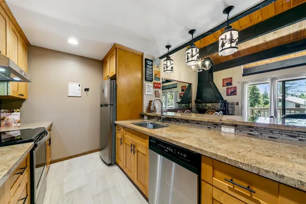 a kitchen with stainless steel appliances granite countertop a stove a sink and a microwave