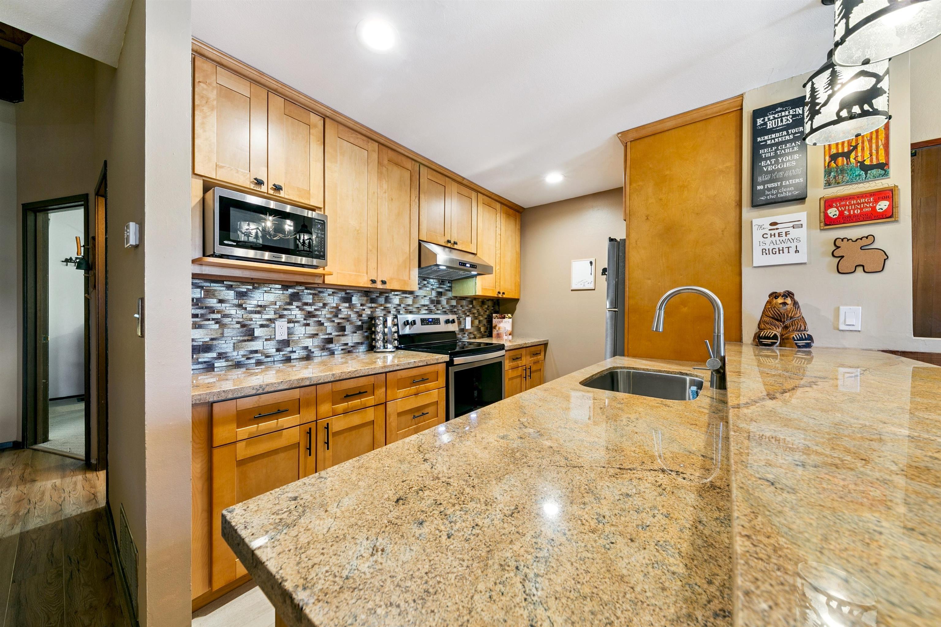 1001 Commonwealth Drive, Unit 106 Kings Beach, CA 96143 - Photo 3 of 27 a kitchen with stainless steel appliances granite countertop a stove a sink and a microwave