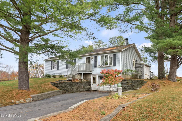 a view of a house with a tree in the yard