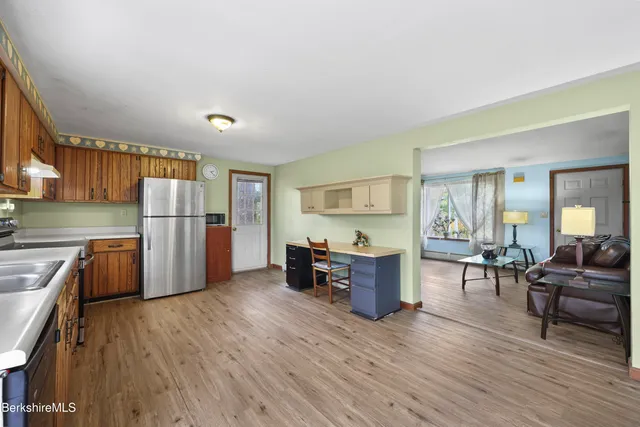 a kitchen with stainless steel appliances a refrigerator and wooden floor