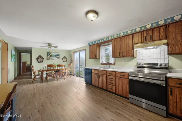 a kitchen with stainless steel appliances granite countertop wooden floors and wooden cabinets