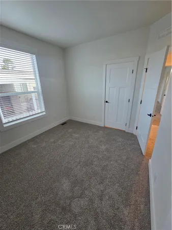 an empty room with a fireplace and windows