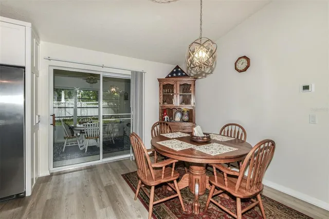 a dining room with furniture a chandelier and wooden floor