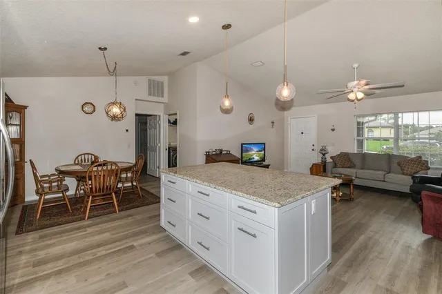 a kitchen with stainless steel appliances granite countertop a stove and a wooden floor