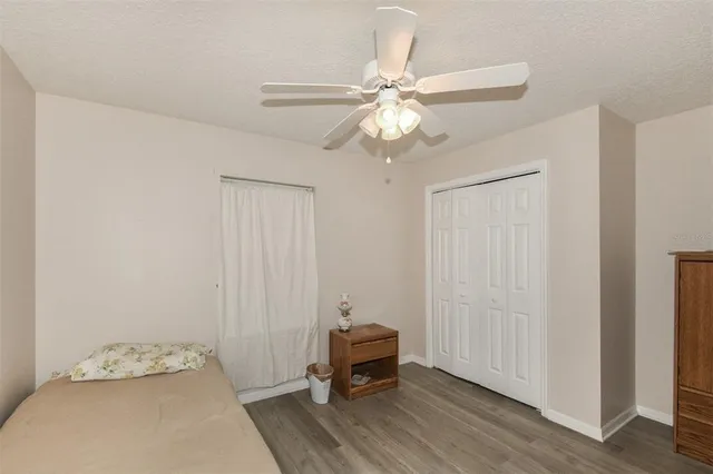 a bedroom with a bed and a chandelier fan