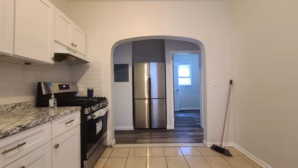 a kitchen with stainless steel appliances granite countertop a refrigerator a stove and a sink