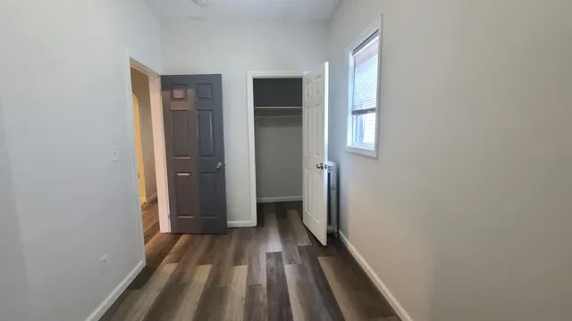 a view of a room with wooden floor and a bathroom