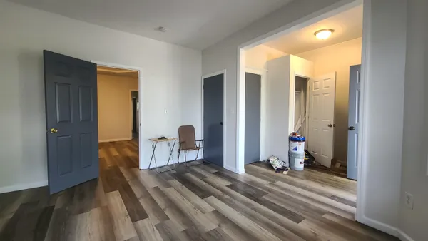 a view of a bedroom with wooden floor and windows