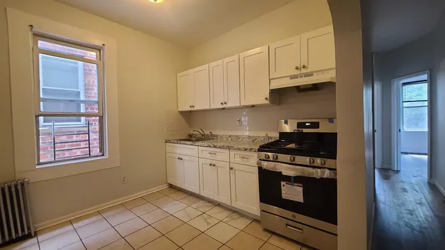 a kitchen with granite countertop white cabinets and appliances