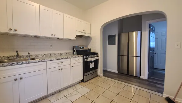 a kitchen with granite countertop white cabinets and stainless steel appliances