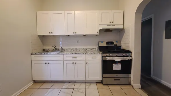 a kitchen with granite countertop white cabinets and stainless steel appliances
