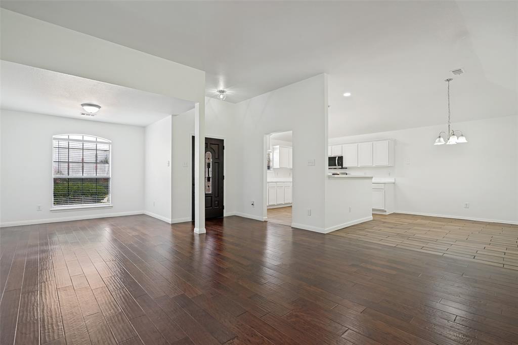 3111 Creekside Drive Sachse, TX 75048 - Photo 4 of 25 Spacious living area featuring wood-finish flooring, white walls, and a large arched window with blinds