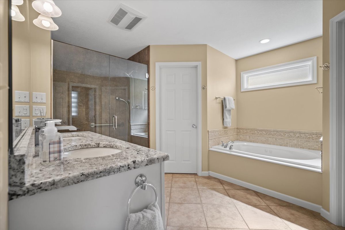 1721 Partridge Point Normal, IL 61761 - Photo 26 of 37 a spacious bathroom with a granite countertop sink a mirror and a bathtub