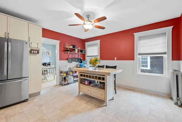 a work room with furniture a ceiling fan and a window