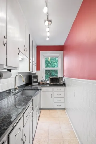 a large kitchen with granite countertop a sink and a stove