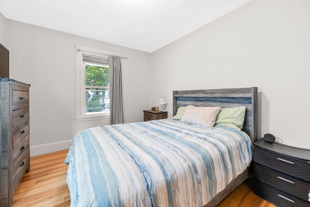 59 Leach Street, Unit 2 Salem, MA 01970 - Photo 25 of 38 a bed sitting in a bedroom next to a window with lamp