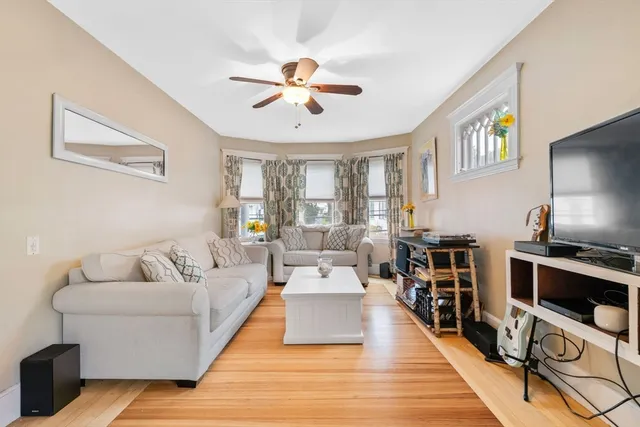 a living room with furniture and a wooden floor