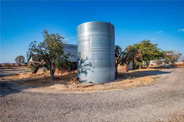 an empty room with a fan & windows