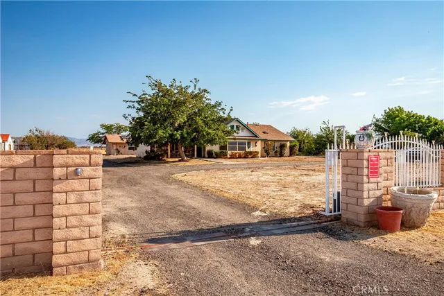 a front view of a house with a yard covered with trees