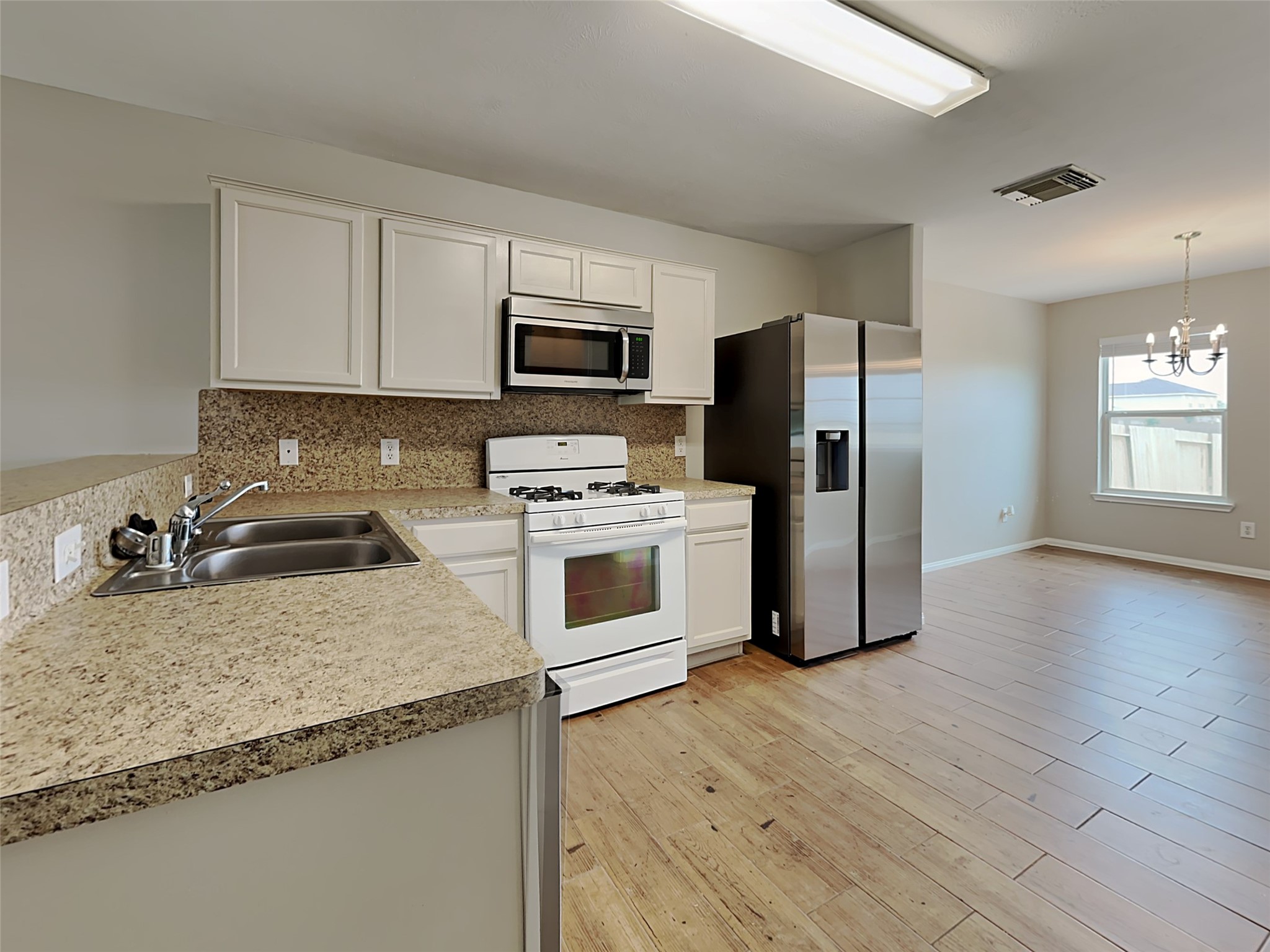 8119 Katie Mill Trail Spring, TX 77379 - Photo 12 of 18 a kitchen with granite countertop a refrigerator a stove a sink a microwave and cabinets
