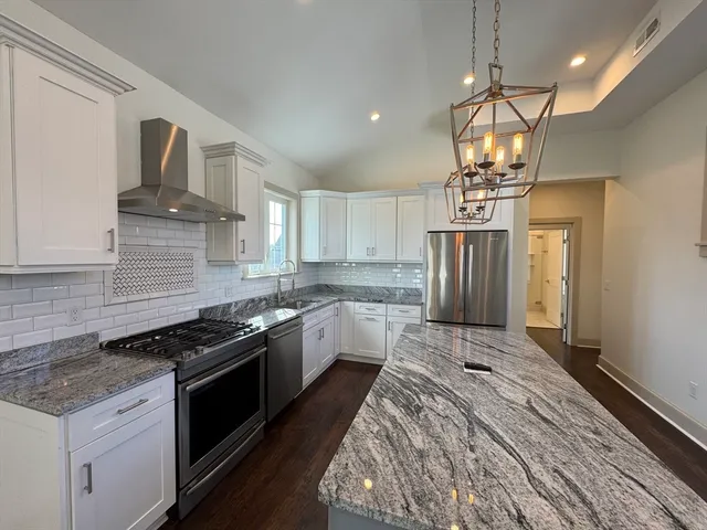 a kitchen with stainless steel appliances granite countertop a sink stove and refrigerator