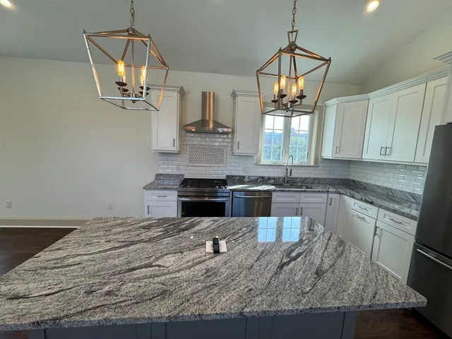 a kitchen with kitchen island granite countertop a sink stainless steel appliances and window