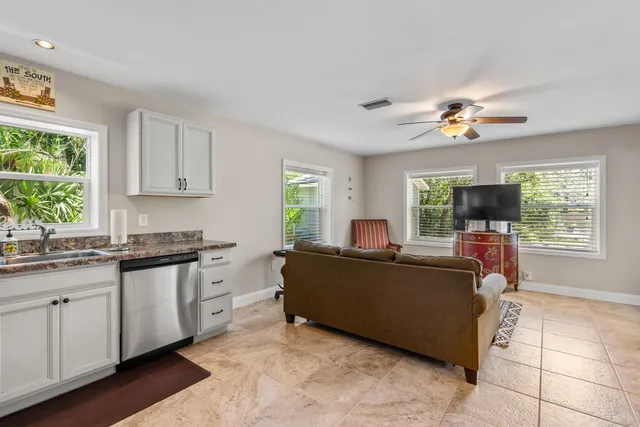 a living room with stainless steel appliances granite countertop furniture a flat screen tv and a window