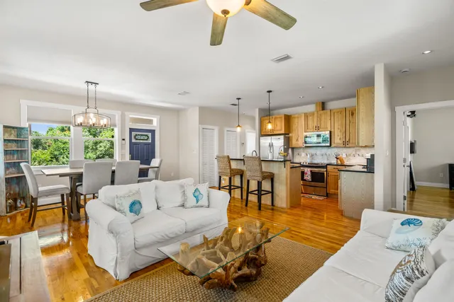 a living room with furniture wooden floor dining table and a chandelier