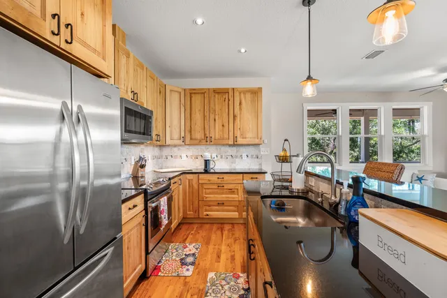 a kitchen with stainless steel appliances granite countertop a stove top oven a refrigerator a sink and dishwasher