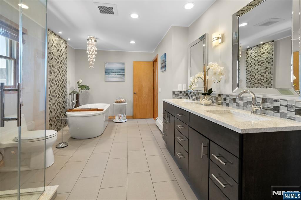 66 Roehrs Drive Wallington, NJ 07057 - Photo 18 of 37 a spacious bathroom with a double vanity sink toilet and a mirror