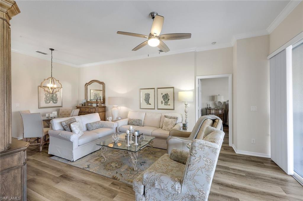 6879 Redbay Park Road, Unit 203 Naples, FL 34109 - Photo 13 of 43 Living area with crown molding, light wood-type flooring, ceiling fan, and hanging lights