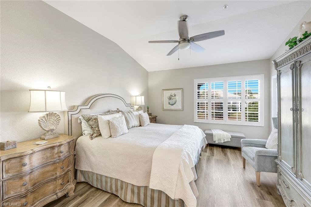 6879 Redbay Park Road, Unit 203 Naples, FL 34109 - Photo 19 of 43 Bedroom with wood finished floors, vaulted ceiling, and a ceiling fan