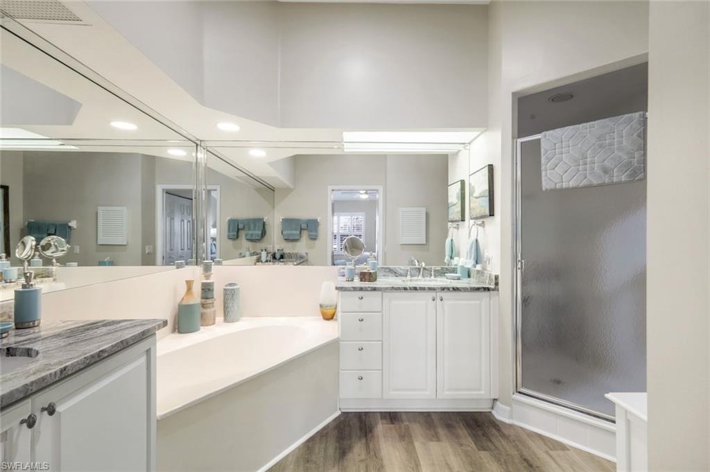 6879 Redbay Park Road, Unit 203 Naples, FL 34109 - Photo 21 of 43 Bathroom featuring a stall shower, two vanities, light wood-type flooring, recessed lighting, and a bath