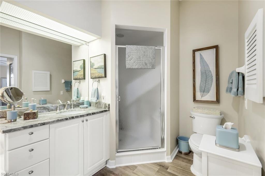 6879 Redbay Park Road, Unit 203 Naples, FL 34109 - Photo 22 of 43 Bathroom with vanity, a shower stall, and light wood-style flooring