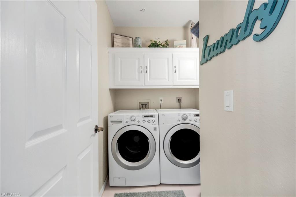 6879 Redbay Park Road, Unit 203 Naples, FL 34109 - Photo 27 of 43 Laundry area with cabinet space, independent washer and dryer, and light tile patterned floors
