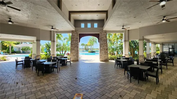 a living room with lots of furniture windows and a chandelier