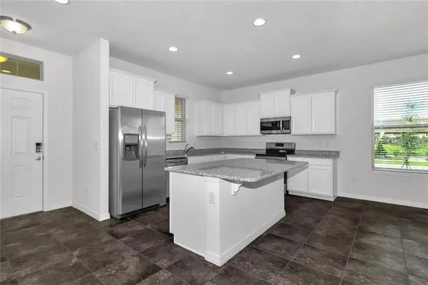 a kitchen with stainless steel appliances granite countertop a refrigerator and a stove top oven