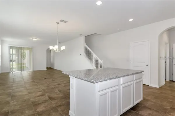 a kitchen with a sink chandelier and refrigerator