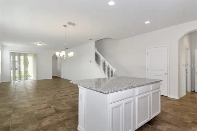 a kitchen with a sink chandelier and refrigerator