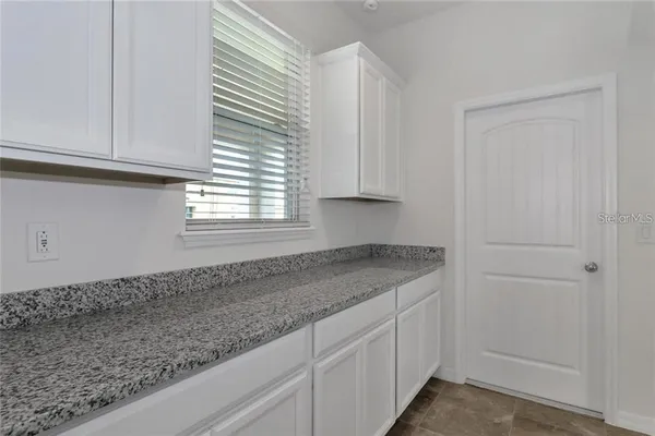 a kitchen with granite countertop white cabinets and a window