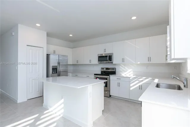 a kitchen with stainless steel appliances a refrigerator sink stove microwave and cabinets