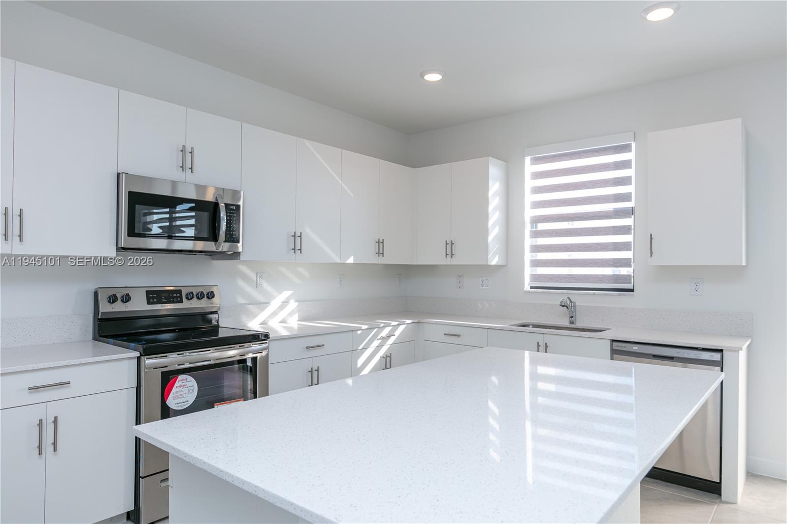 12990 Southwest 229th Lane Miami, FL 33170 - Photo 14 of 43 a kitchen with a sink a stove and cabinets