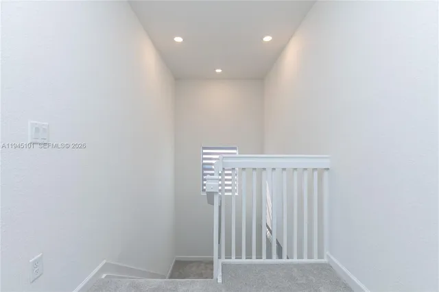 a view of staircase with white walls and white door