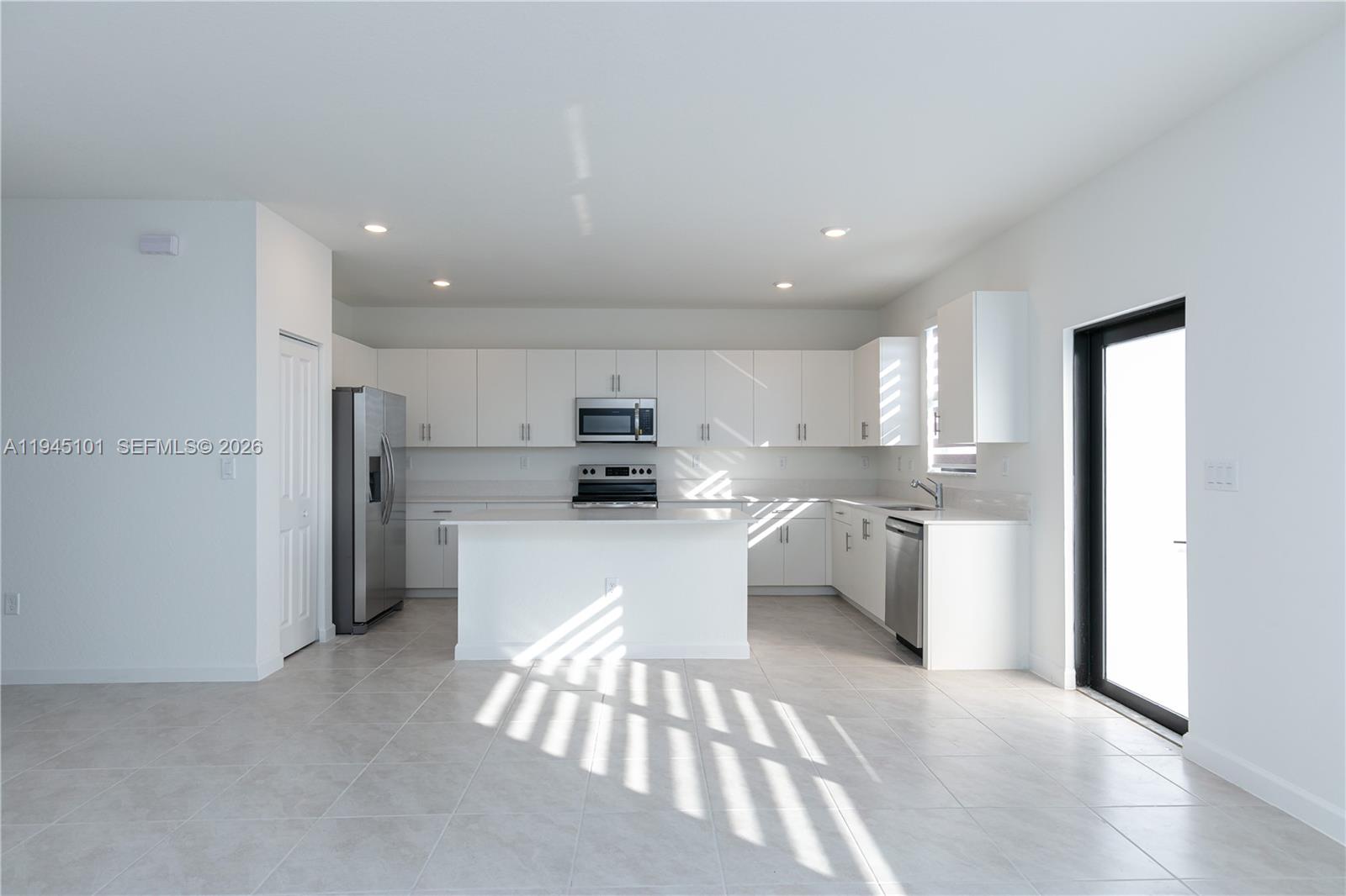 12990 Southwest 229th Lane Miami, FL 33170 - Photo 6 of 43 a kitchen with stainless steel appliances kitchen island sink refrigerator and microwave