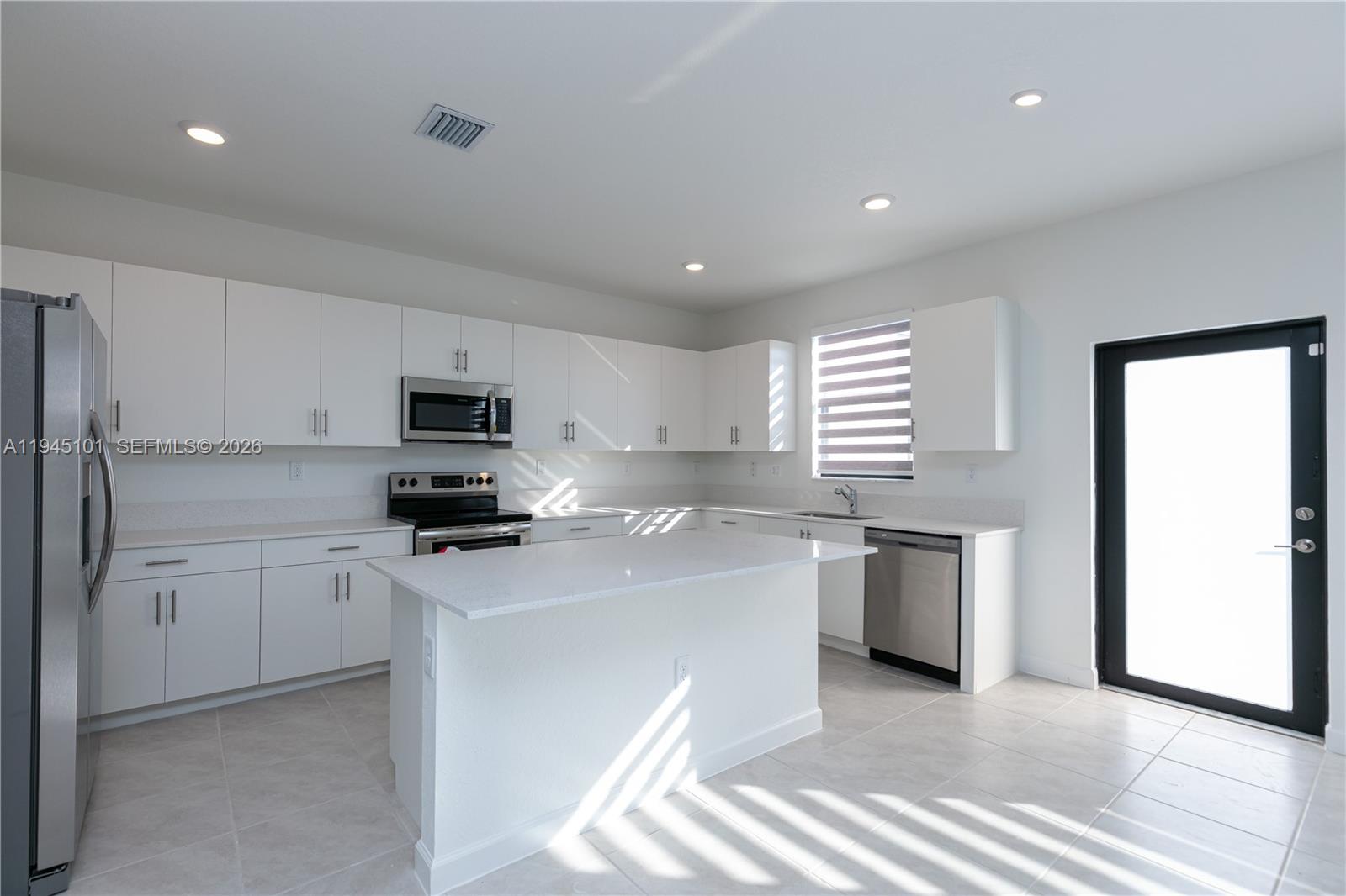 12990 Southwest 229th Lane Miami, FL 33170 - Photo 8 of 43 a kitchen with stainless steel appliances a sink a stove a refrigerator cabinets and a window