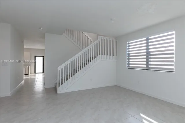 a kitchen with a sink a stove a refrigerator and white cabinets