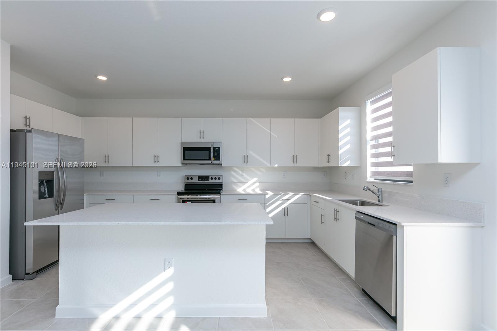 12990 Southwest 229th Lane Miami, FL 33170 - Photo 10 of 43 a kitchen with a sink a stove a refrigerator and white cabinets