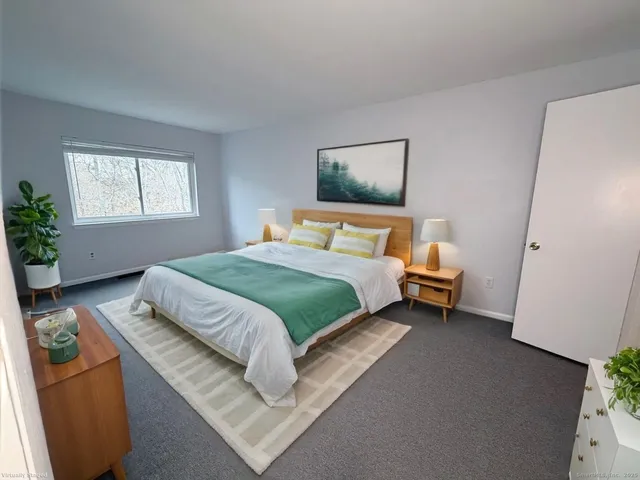 a bedroom with a bed and a potted plant