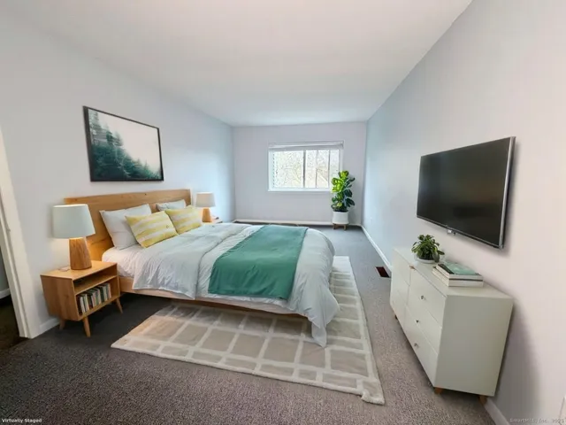 a bedroom with a bed and a flat screen tv